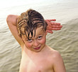 boy posing in sea with hand sign