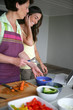 Mother and adult daughter cooking together