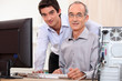 Photo: Man helping granddad with computer Man helping granddad with computer