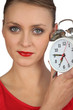 Blond woman displaying alarm clock