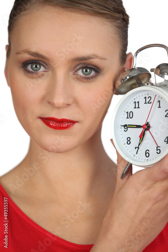 Photo: Blond woman displaying alarm clock Blond woman displaying alarm clock