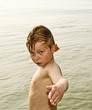child is posing proudly while standing in the cold sea