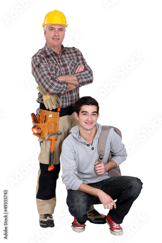 Photo: Experienced tradesman posing with his new apprentice Experienced tradesman posing with his new apprentice