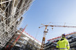 surveyor with instrument inside building-site, super wide view