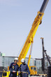 construction workers and giant mobile cranes