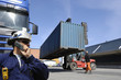 forklift stacking cargo-containers inside commercial port