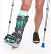 Man with a broken leg with Crutches on a white background