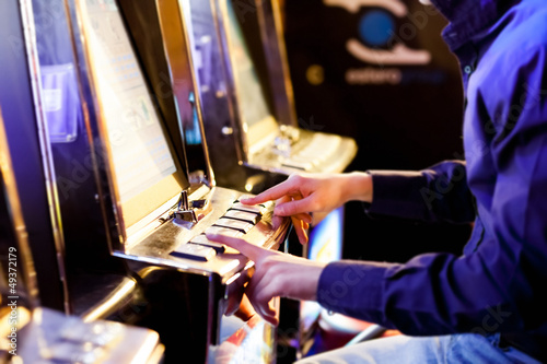 Photo: Man using an electronic slot machine Man using an electronic slot machine