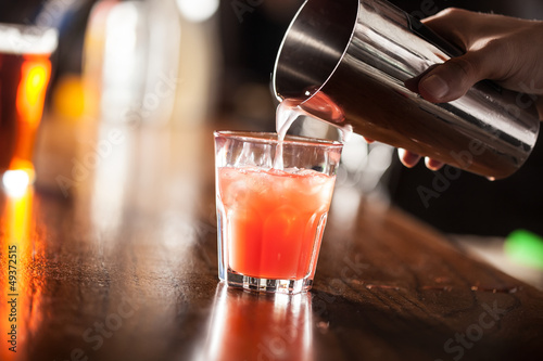 Photo: Barman serving a cocktail from a shaker Barman serving a cocktail from a shaker