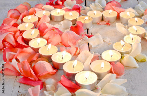 Photo: Brennendes Herz aus Kerzen mit Rosenblütenblättern Brennendes Herz aus Kerzen mit Rosenblütenblättern