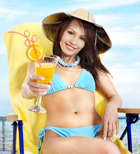 Photo: Girl in bikini drinking orange juice. Girl in bikini drinking orange juice.