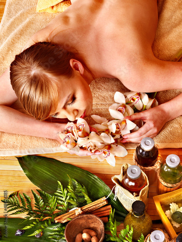 Photo: Woman getting herbal ball massage treatments . Woman getting herbal ball massage treatments .