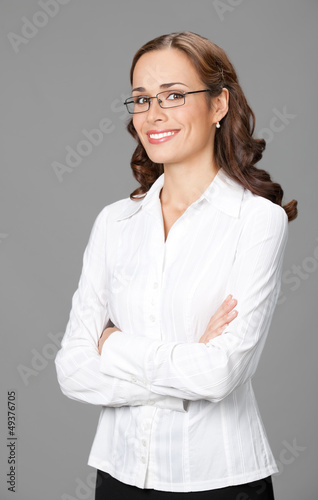 Photo: Smiling businesswoman, over gray Smiling businesswoman, over gray