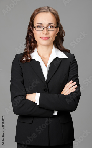 Photo: Smiling businesswoman, over gray Smiling businesswoman, over gray