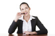 Photo: Pretty business woman in sitting at the desk and thinking Pretty business woman in sitting at the desk and thinking