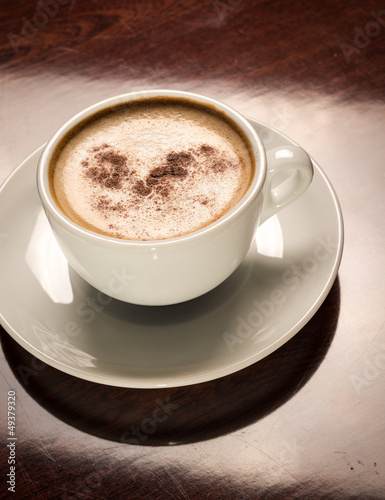 Photo: Cup of coffee on a wooden table in restaurant Cup of coffee on a wooden table in restaurant