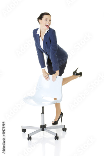 Photo: Businesswoman standing next to ofice chair Businesswoman standing next to ofice chair