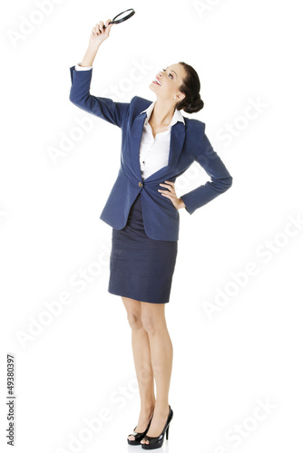 Photo: Business woman looking into a magnifying glass Business woman looking into a magnifying glass