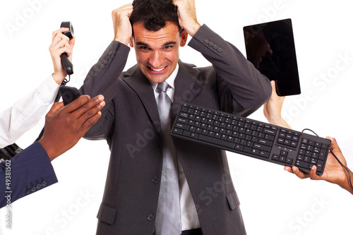 Photo: frustrated businessman around by multiple office tools frustrated businessman around by multiple office tools