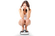 Young woman sitting on her haunches on a scale