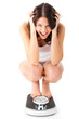 Young woman sitting on her haunches on a scale