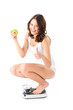 Young woman sitting on her haunches on a scale