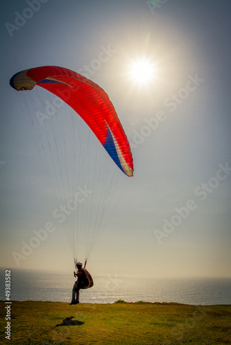 Photo: Paraglider taking off from a mountain Paraglider taking off from a mountain