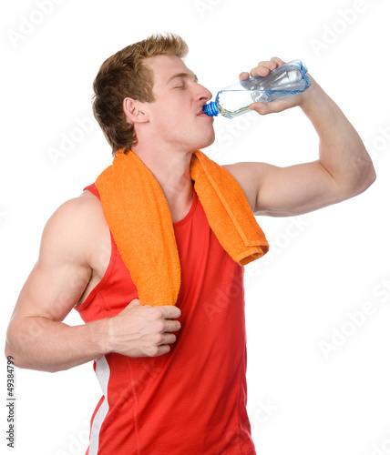 Photo: sportsman drinks water from a bottle. isolated on white sportsman drinks water from a bottle. isolated on white