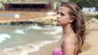 Pensive beautiful woman on the beach