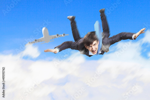 Photo: Young businessman flying with parachute on back Young businessman flying with parachute on back