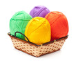 four yarn skeins in yellow, orange, green, purple colors in bask