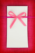 Empty card on pink fabric texture