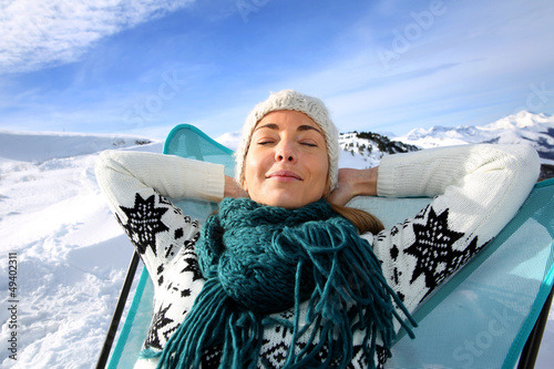 Photo: Woman in ski resort relaxing in long chair Woman in ski resort relaxing in long chair