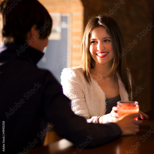 Photo: Couple of friends having a round of drinks Couple of friends having a round of drinks