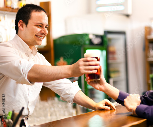 Photo: Bartender serving a beer Bartender serving a beer