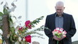 Man standing at new grave close