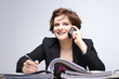 Junge Geschäftsfrau telefoniert am Arbeitsplatz