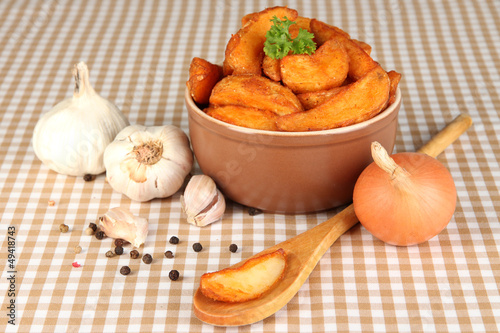 Photo: Appetizing village potatoes in bowl on beige tablecloth Appetizing village potatoes in bowl on beige tablecloth