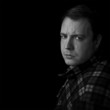 man with serious expression looking to camera
