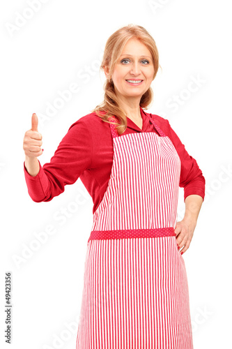 Photo: A female manual worker wearing an apron and giving thumb up A female manual worker wearing an apron and giving thumb up
