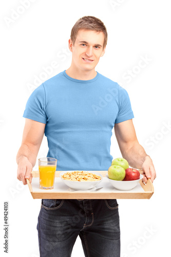 Photo: A smiling carrying a wooden tray with drinks and food A smiling carrying a wooden tray with drinks and food