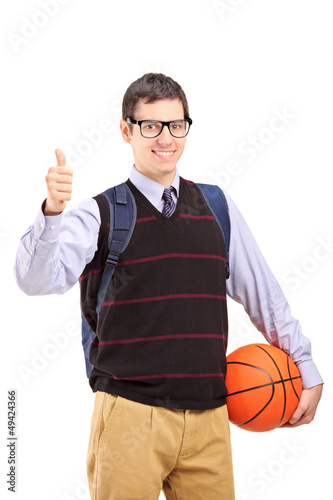 Photo: Male student with school bag holding a basketball and giving thu Male student with school bag holding a basketball and giving thu