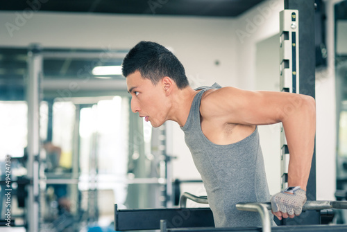 Photo: Young asian man training in the gym. Young asian man training in the gym.