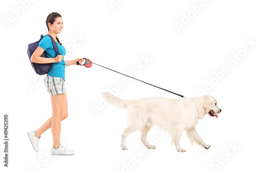 Photo: Full length portrait of a female student walking her dog Full length portrait of a female student walking her dog