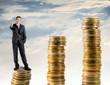 Businessman standing on a stack of money