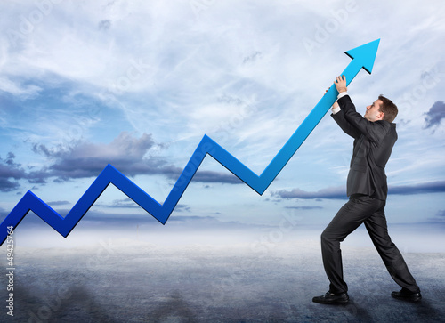 Photo: Businessman pushing a graphic arrow up Businessman pushing a graphic arrow up