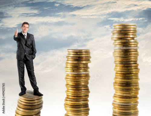 Photo: Businessman standing on a stack of money Businessman standing on a stack of money