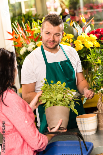 Photo: Smiling male florist selling potted plant flower Smiling male florist selling potted plant flower