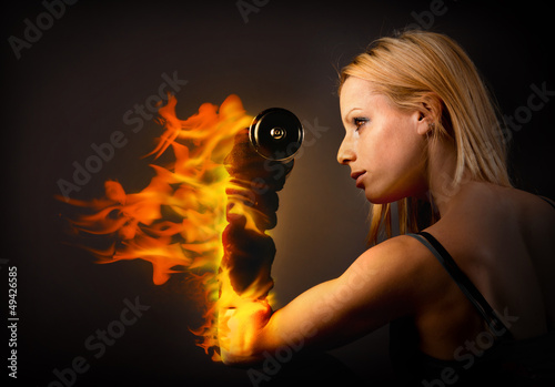 Fototapeta Woman lifting a weight on fire