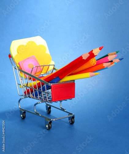 Photo: trolley with school equipment on blue background trolley with school equipment on blue background
